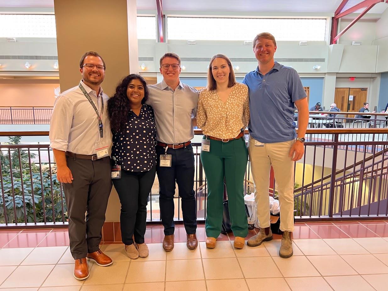 group picture of five pediatric residents standing in main hospital lobby